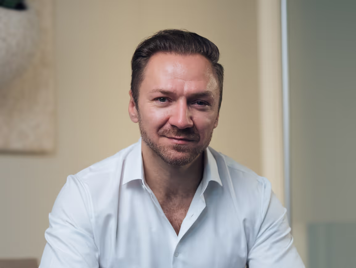 Professionelles Porträtfoto von Gregor Wojtowicz aus Köln in weißem Hemd vor hellem Hintergrund